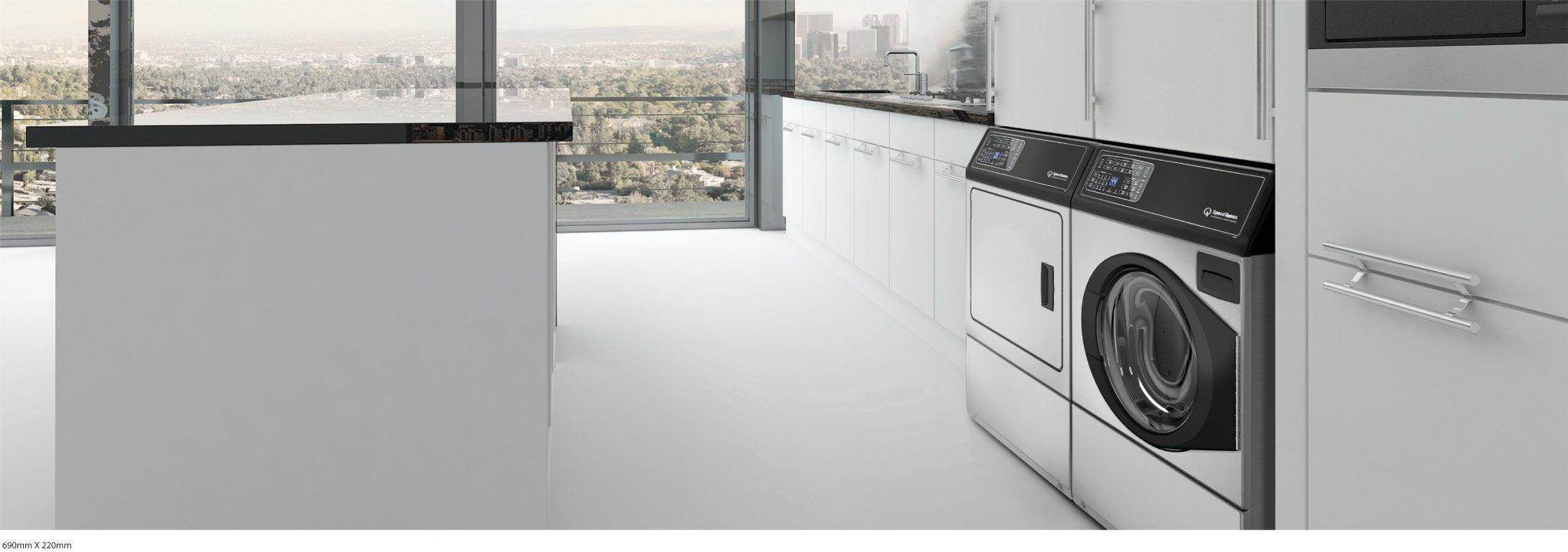 Modern kitchen with large windows, built-in laundry appliances, and sleek white cabinetry