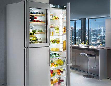 Modern kitchen with glass-front upright refrigerator, fully stocked with food and drinks