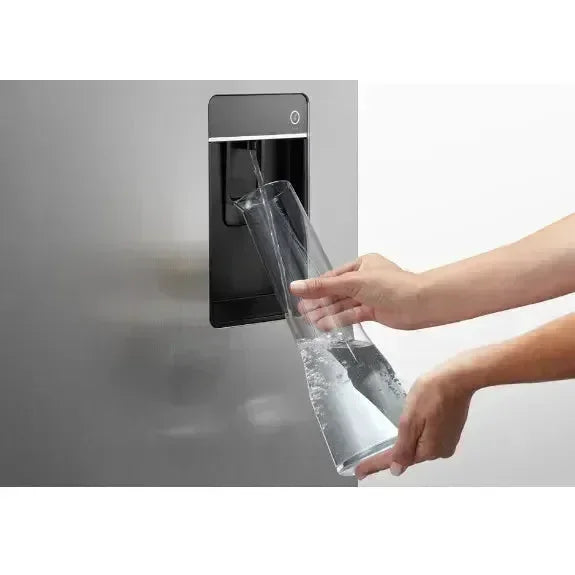 Hand filling glass jug with water from refrigerator dispenser