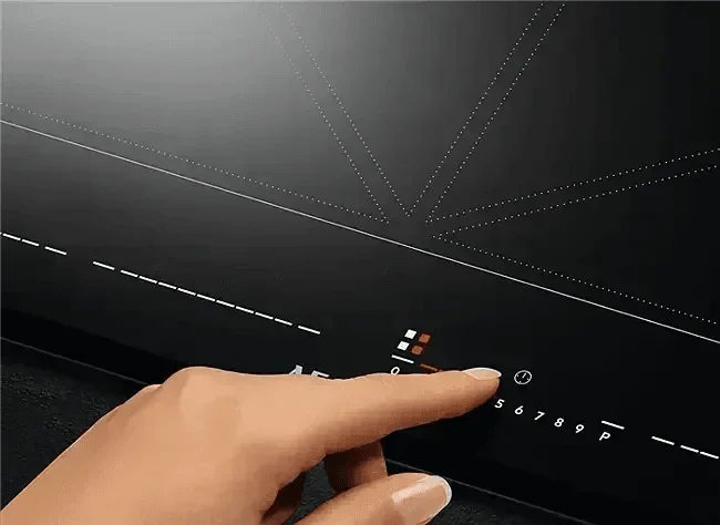 Hand using touch control panel on AEG 80cm Induction Cooktop