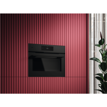 AEG 45cm COMBIQUICK® Oven NKK8A701T black compact oven installed in a red textured wall.