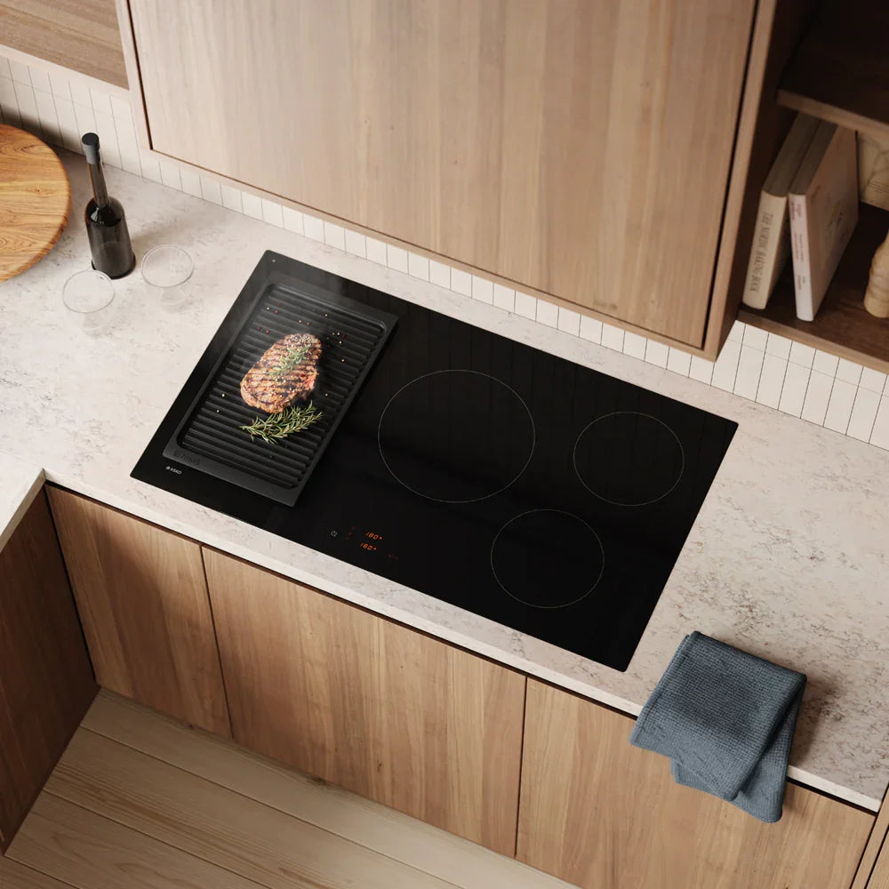 Falcon premium European glass black induction cooker with grilled steak on modern kitchen counter