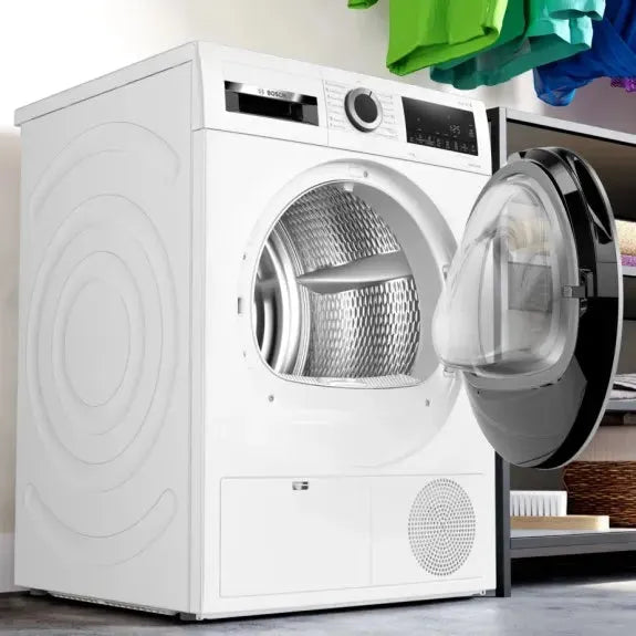 White front-load washing machine with open door, showing stainless drum, in modern laundry space