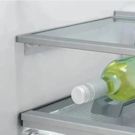 Modern refrigerator interior with glass shelves and wine bottle storage