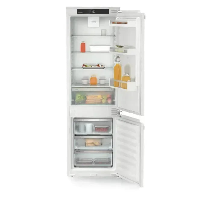 White built-in refrigerator with open doors, showcasing organized shelves and fresh food storage compartments.