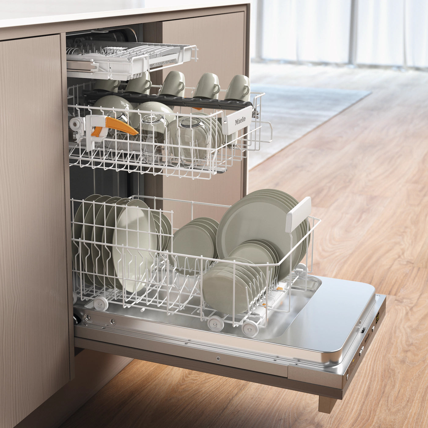Miele built-in dishwasher with open racks holding clean plates, cups, and glasses in modern kitchen