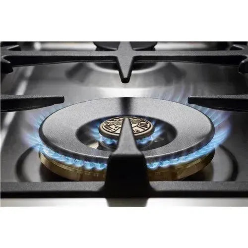 Blue flame gas burner on stainless steel cooktop, designer kitchen appliance