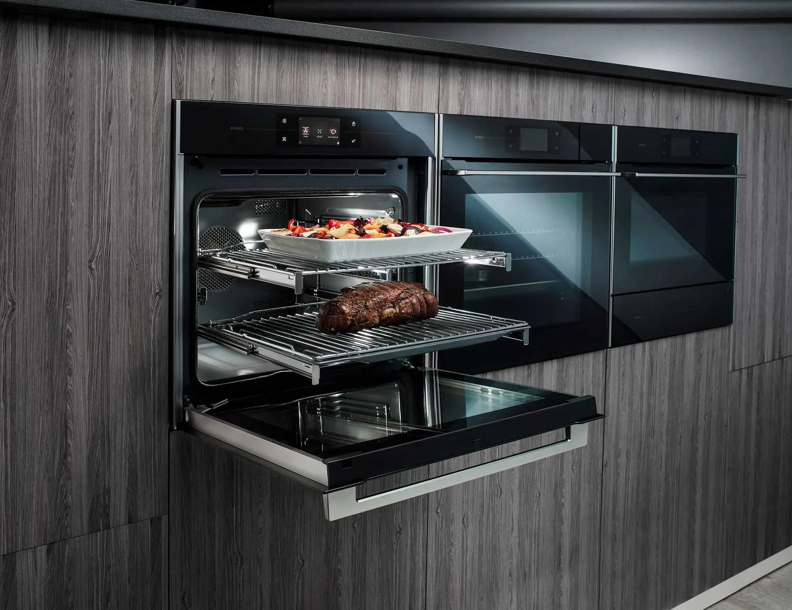 Modern built-in oven baking roast and veggies in sleek kitchen with designer appliances