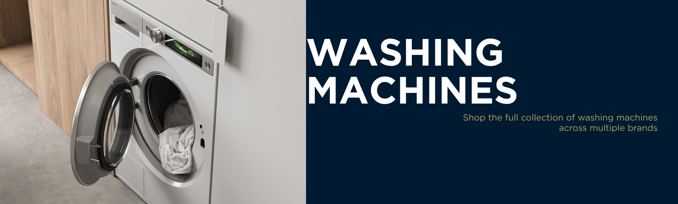 Front load washing machine with open door, showing laundry inside, modern kitchen setting