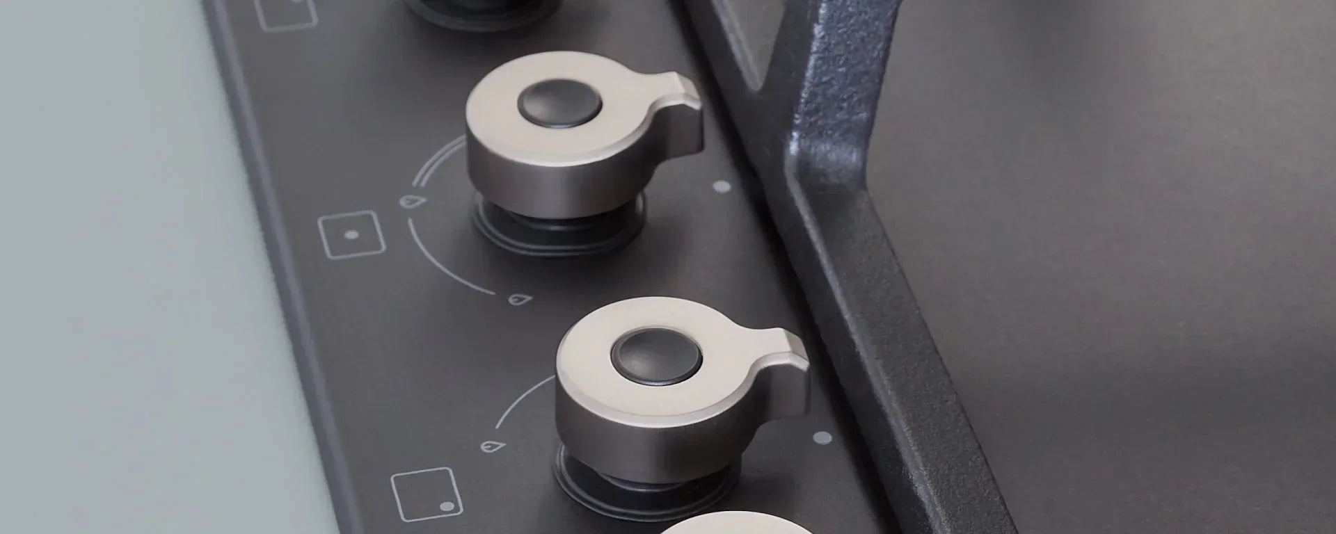 Close-up of sleek metal control knobs on a modern kitchen appliance