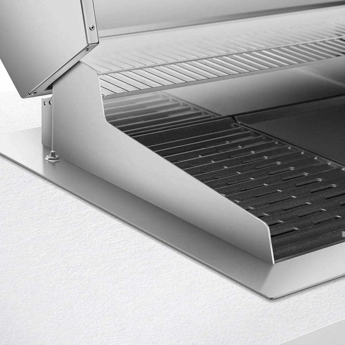 Close-up of the stainless steel grill grate and drip tray of a Smeg built-in electric barbecue.