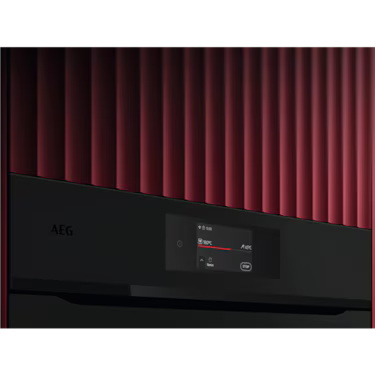 AEG 60cm Pyrolytic Oven Matte Black NBE7P731AT installed in a red textured wall highlighting the touch display.