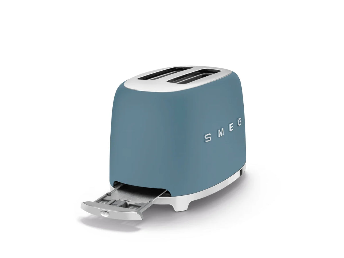 Smeg 50's Style 2 Slice Toaster TSF01SBMAU this view of the storm blue toaster shows the chrome crumb tray open and SMEG logo across the middle of the toaster.