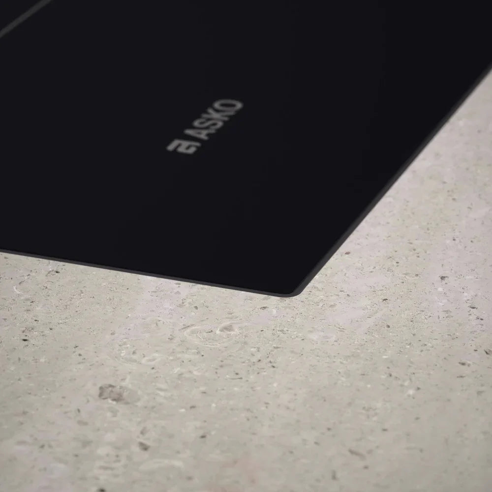 ASKO black glass induction cooktop on stone countertop