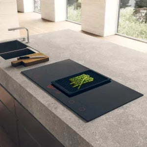 Falcon premium European glass black induction cooker with asparagus on sleek kitchen countertop