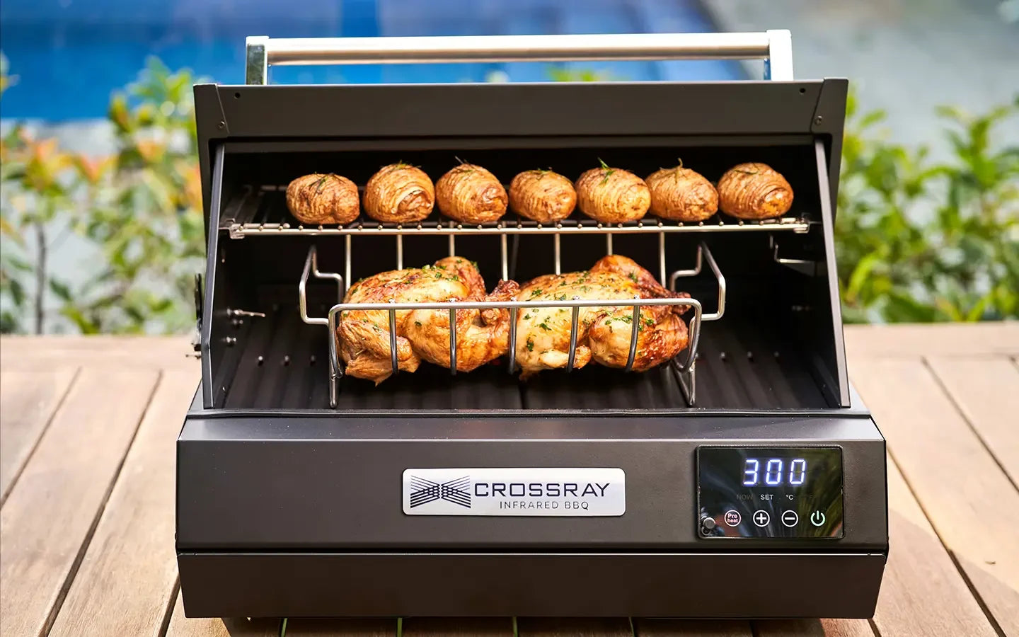 Crossray infrared BBQ grill cooking chicken and potatoes outdoors