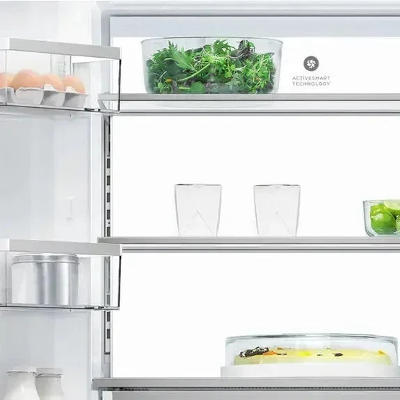 Modern refrigerator interior with fresh greens, eggs, and drinks on sleek shelves, featuring ActiveSmart Technology.