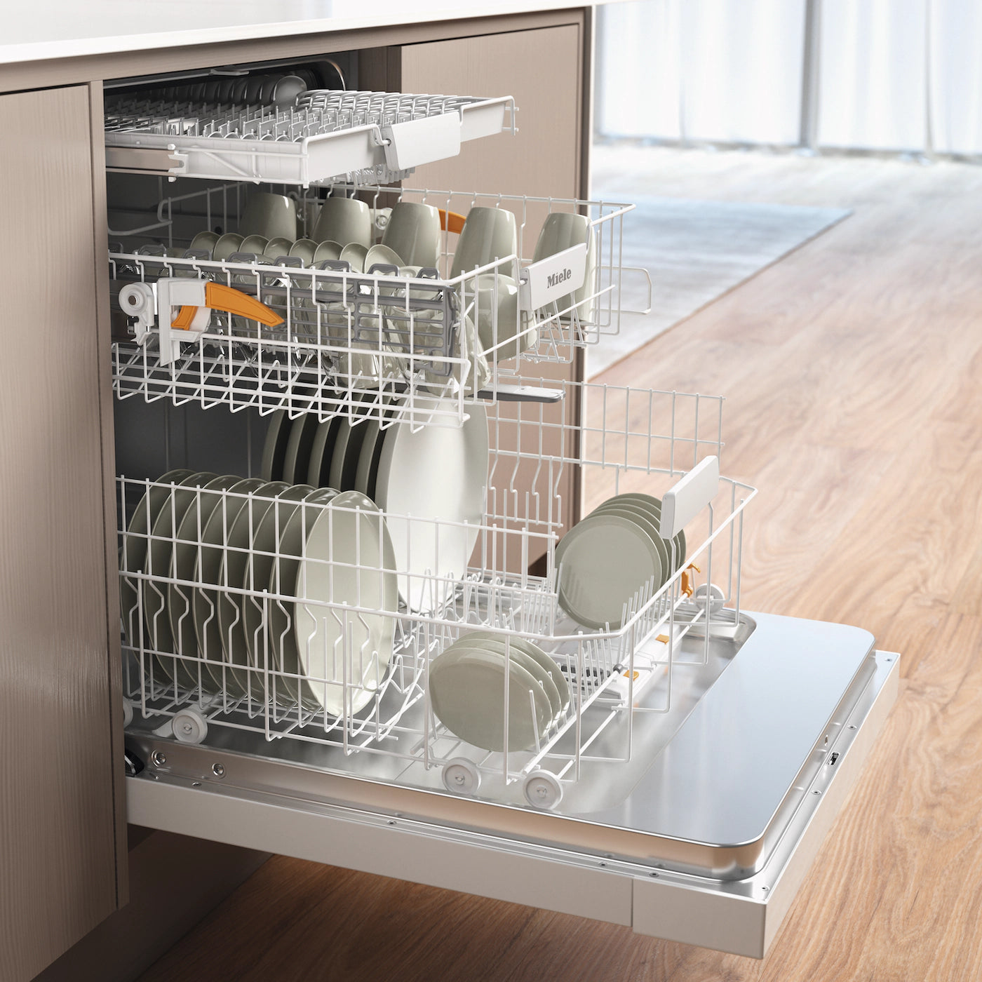 Miele built-in dishwasher with open racks holding clean dishes in modern kitchen