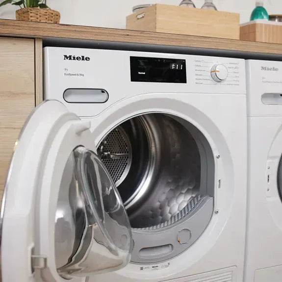 Miele front load washer with open door, sleek white design for modern kitchen appliances