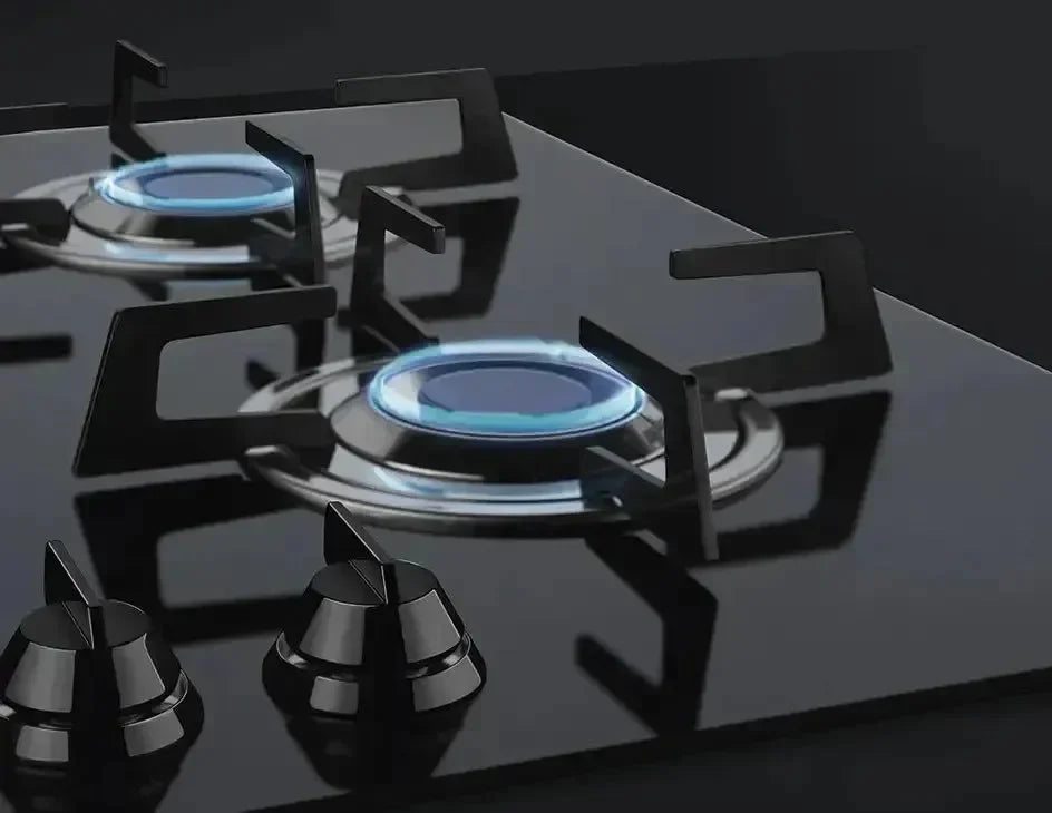 Modern black glass gas cooktop with blue flames and sleek control knobs for designer kitchens