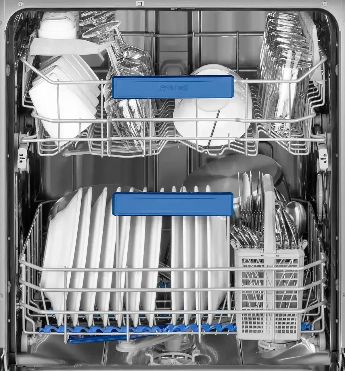Smeg dishwasher interior with clean dishes, glassware, and utensils loaded in racks