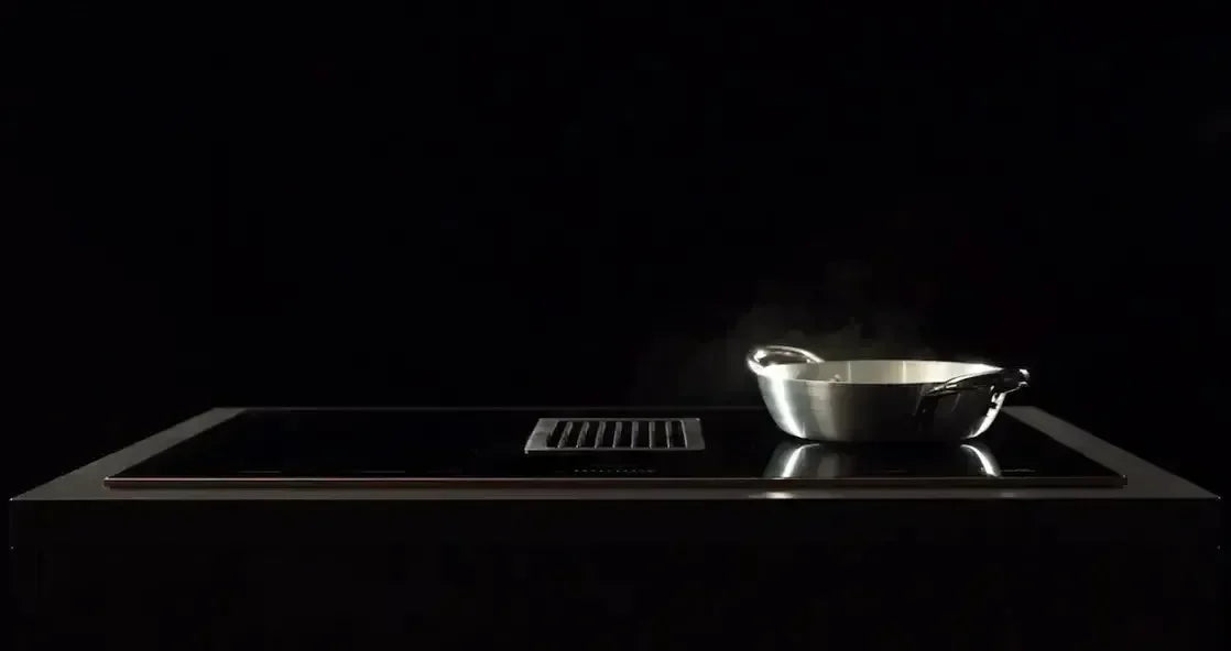 Modern induction cooktop with stainless steel pan steaming, sleek black kitchen appliance
